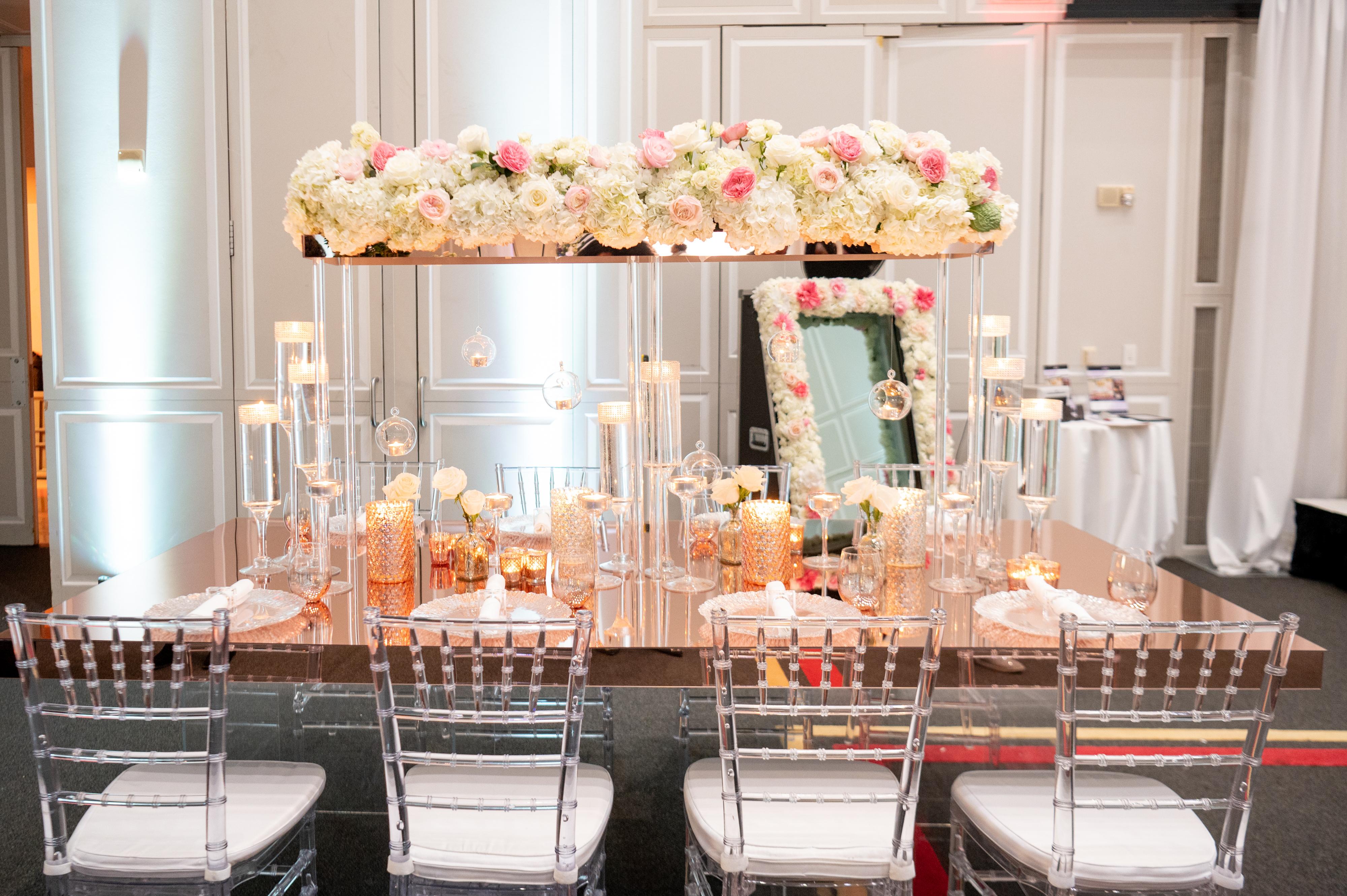 Long table set with tiers of white and pink flowers
