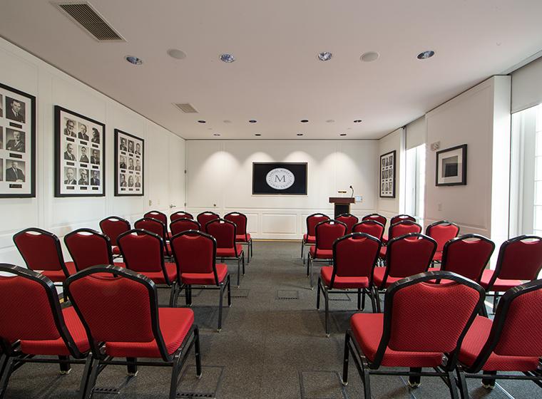 Small meeting room set theater style with red and black conference chairs
