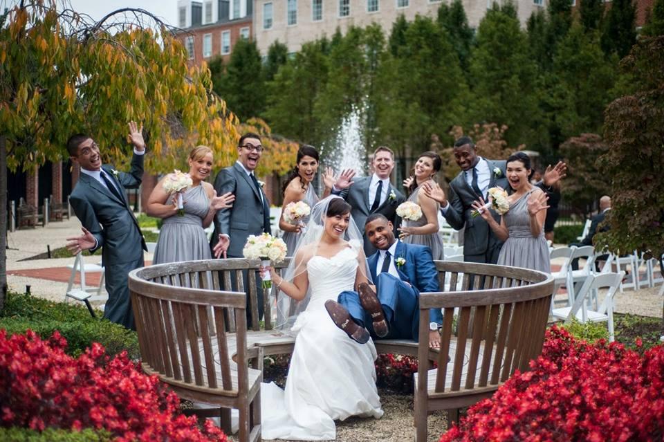 Bridal party on and around bench in garden